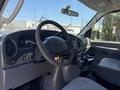 Interior of a 2006 Ford Econoline featuring a steering wheel dashboard control panel and gray upholstery