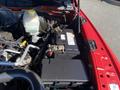 A close-up view of the engine compartment of a 2015 RAM 2500 showing the battery and other engine components