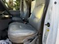 A gray leather seat of a 2007 Ford Econoline van positioned in the driver's area with a visible seatbelt and console