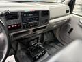 The interior of a 2000 Ford F-450 showing the dashboard with controls a radio system and a central console area with additional equipment