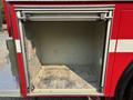 An empty cargo compartment of a 1999 Freightliner FL80 truck with metal sides and a diamond plate floor
