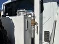Close-up of a valve and hose connection on a 2013 International 7500 truck with a metallic and white finish