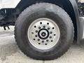 Close-up of a large tire mounted on a 2013 Freightliner 114SD showcasing the tread design and wheel rim details