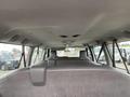Interior view of a 2010 Ford Econoline showing the back seats with overhead lighting and a gray interior design