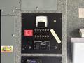A control panel featuring a voltmeter and labeled circuit breakers for a Cummins Onan generator mounted inside a vehicle