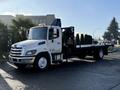 2015 Hino 358 flatbed truck with a cab featuring a large front grille and a small orange light on the roof