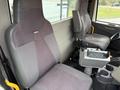 Interior of a 2012 International 7400 truck showing two seats with fabric upholstery and a central control panel visible between them