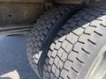 Close-up of two large, worn tires on a 1996 GMC Top Kick showcasing deep tread patterns and visible signs of use