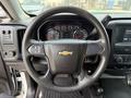 A 2018 Chevrolet Silverado 1500 steering wheel with a Chevrolet logo and various controls visible along with a dashboard featuring gauges and a central infotainment screen
