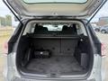 The image shows the spacious interior of a 2014 Ford Escape with the rear seats folded down and a flat cargo area complete with compartments for storage