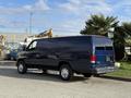 A blue 2011 Ford Econoline van parked with a clean exterior and four doors visible from the side view