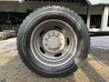 A close-up of a silver rim and tire of a 2015 Ford F-550 showcasing the tread pattern and wheel design
