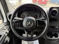 Steering wheel of a 2022 Mercedes-Benz Sprinter displaying controls and a central emblem with instrument cluster visible behind