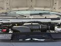 Engine compartment of a 2008 Ford Econoline showing the air intake and various components including the battery and hoses