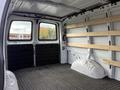 Interior of a 2023 GMC Savana van showing a spacious cargo area with wood slats along the walls and a textured floor