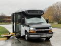 A 2019 Chevrolet Express van with a wheelchair lift on the side is parked with its doors open