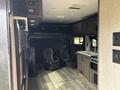 Interior of a 2021 Jayco Jay Flight showing two leather recliners and a kitchenette with cabinets and appliances