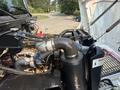 Close-up view of the engine compartment of a 1999 Freightliner FL80 highlighting the turbocharger and air intake system