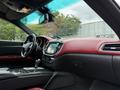 Interior of a 2016 Maserati Ghibli featuring a luxurious red and black color scheme with a sleek dashboard and modern controls