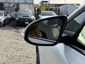 A close-up of the side mirror of a 2021 Toyota C-HR reflecting the surroundings