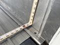 A measuring tape laid across metal surfaces showing measurements in inches and centimeters