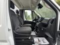 Inside view of a 2023 RAM Promaster 3500 showing two front seats and the driver’s area with dashboard controls and storage compartments