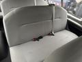 The interior of a 2013 Ford E-350 featuring a gray upholstered bench seat with seatbelts and a simple, functional design