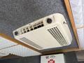 An air conditioning unit mounted on a ceiling with controls for temperature and airflow visible
