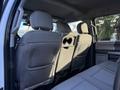 Interior view of the back seat of a 2020 Ford F-350 featuring gray upholstery with two headrests visible and a central cup holder in the armrest