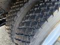 Close-up of a rugged tire from a 2015 Hino 358 with deep treads designed for traction and durability