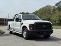 A white 2008 Ford F-250 SD pickup truck with a black grille and a regular cab design parked on a road