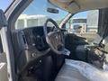 Interior of a 2011 Chevrolet Express showing the steering wheel dashboard and driver's seat with light-colored upholstery and a plastic covering on the seat