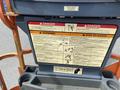 A control panel of a 2009 JLG E300AJP with warning and danger signs related to electrocution and operational hazards