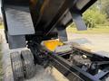 A 2022 Ford F-550 vehicle with its dump bed raised exposing the chassis and hydraulic components underneath