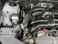Image shows the engine compartment of a 2016 Subaru Forester with visible components such as the air intake and various hoses and wiring.