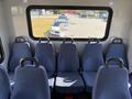 Interior view of a 2017 Chevrolet Express showing eight blue fabric seats arranged in rows with armrests and seatbelts