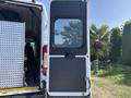 A 2022 RAM Promaster 350 with a partially open rear door showcasing a black panel and window