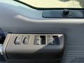 A control panel featuring four window and lock buttons in a 2015 Ford F-550 truck interior