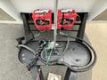 The image shows the front hitch assembly of a 2013 Outdoor Wind River trailer featuring two red battery boxes connected by cables and a metal chain secured to the hitch plate