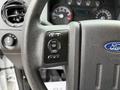 Close-up of a 2015 Ford F-350 SD steering wheel featuring control buttons for cruise control and vehicle settings