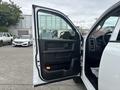 A 2016 RAM 1500 with the driver's side door open showcasing the interior door panel and controls