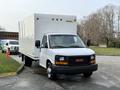 A white 2015 GMC Savana box truck parked in a lot with a simple front design featuring a black grille and headlights