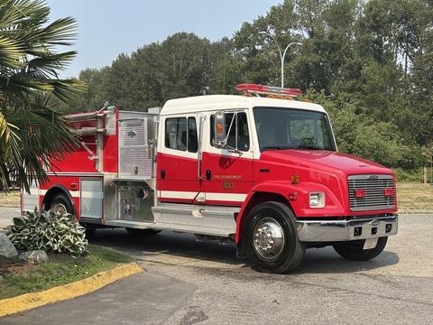 A red 1999 Freightliner FL80 fire truck with a silver chassis and emergency lights on top parked at an angle with a fire hose compartment on the side