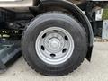 Close-up of a large tire from a 2009 UD Trucks UD 3300 featuring a gray wheel rim and a Michelin brand tire with a rugged tread pattern