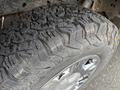 Close-up of a rugged tire mounted on a chrome wheel showcasing deep treads designed for off-road traction and durability