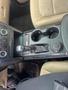 The interior console of a 2016 Ford Explorer featuring a gear shifter climate controls and cup holders