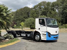 A 2022 Lion Lion6 truck with a white cab and blue accents is parked, featuring a chassis without a freight box
