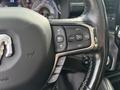 A close-up view of the steering wheel of a 2021 RAM 1500 featuring control buttons for cruise control and gear limit settings