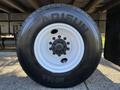 A close-up of a 2012 Freightliner M2 106 tire featuring a white rim and black tire with the brand name Arisun and model number 4759 printed on the side