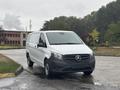 A 2021 Mercedes-Benz Metris van with a white body and black front grille parked on a wet road